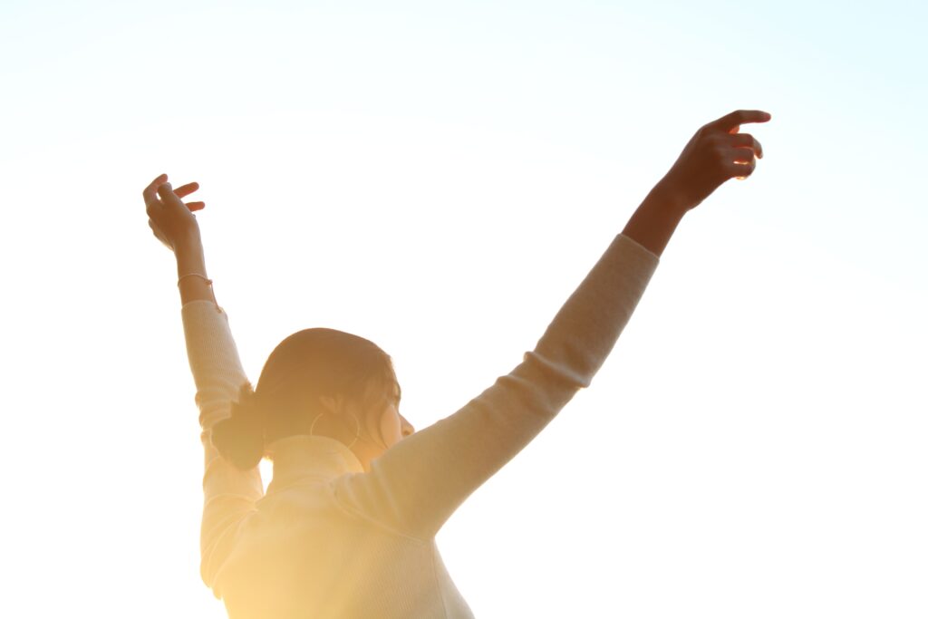 Christian woman praying with lifted hands, reconnecting with Jesus in worship
